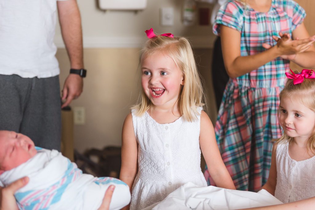 Siblings meeting baby for first time